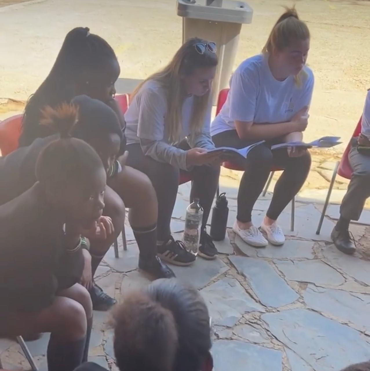 Learners and volunteers sharing books in a circle